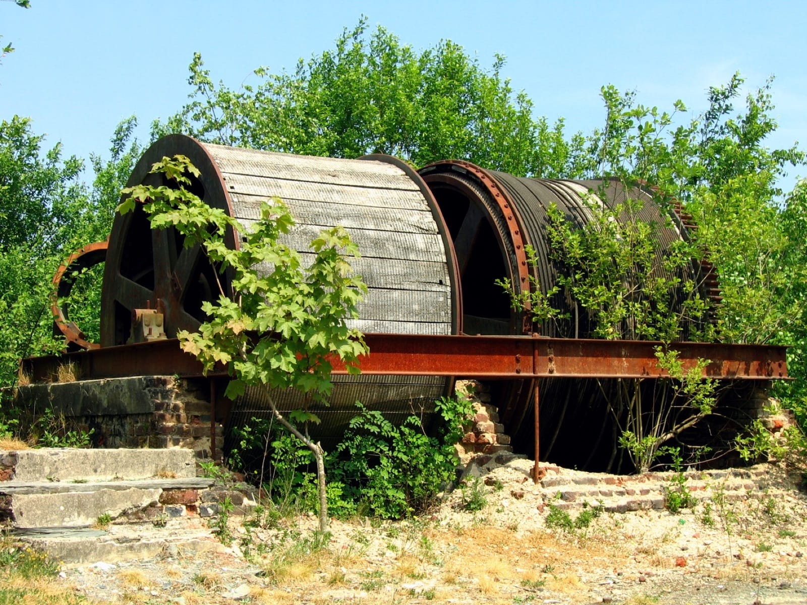 Vue ancienne des ardoisières de Rimogne, dans les Ardennes, avec chevalements et ouvriers.