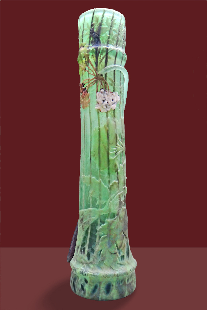 Vase en verre de l’École de Nancy à décor floral en relief, ombelles et feuillages dans des tons verts, présenté sur un fond sombre