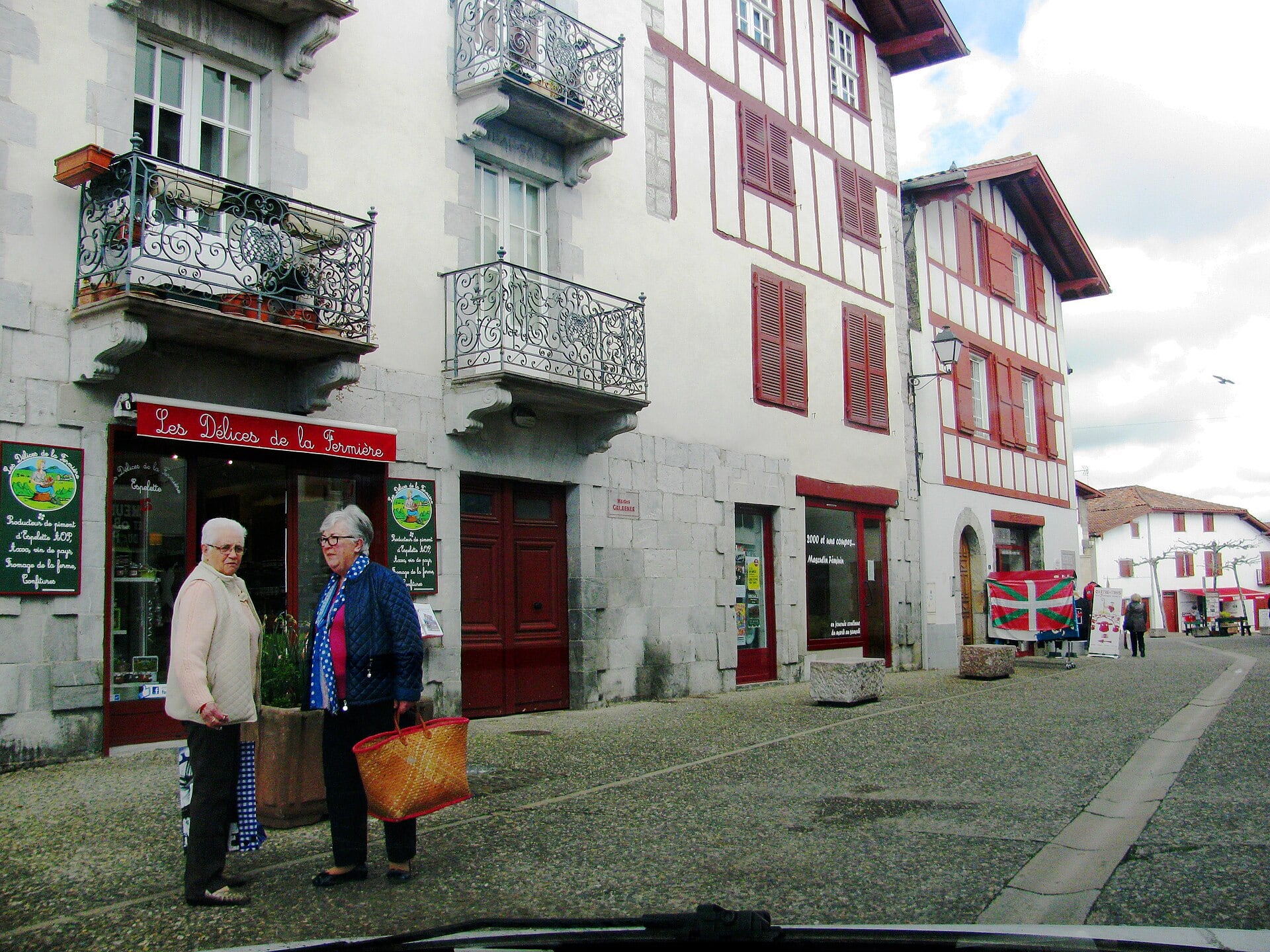 Rue basque mêlant maison de pierre de taille à balcons de fer et maisons à colombage