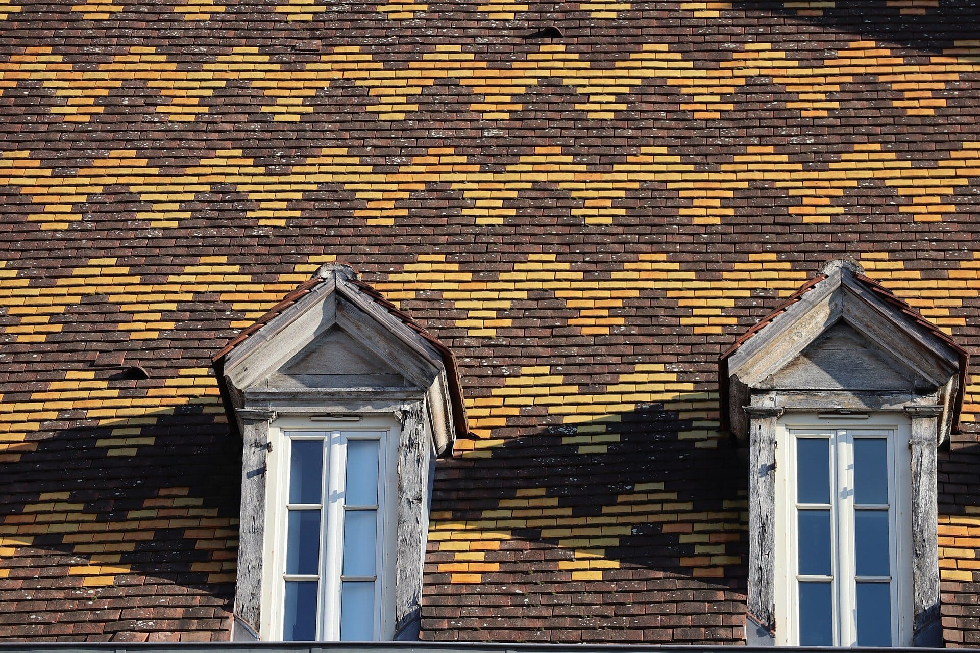 Toit de tuiles vernissées et lucarnes d’une maison de Dijon