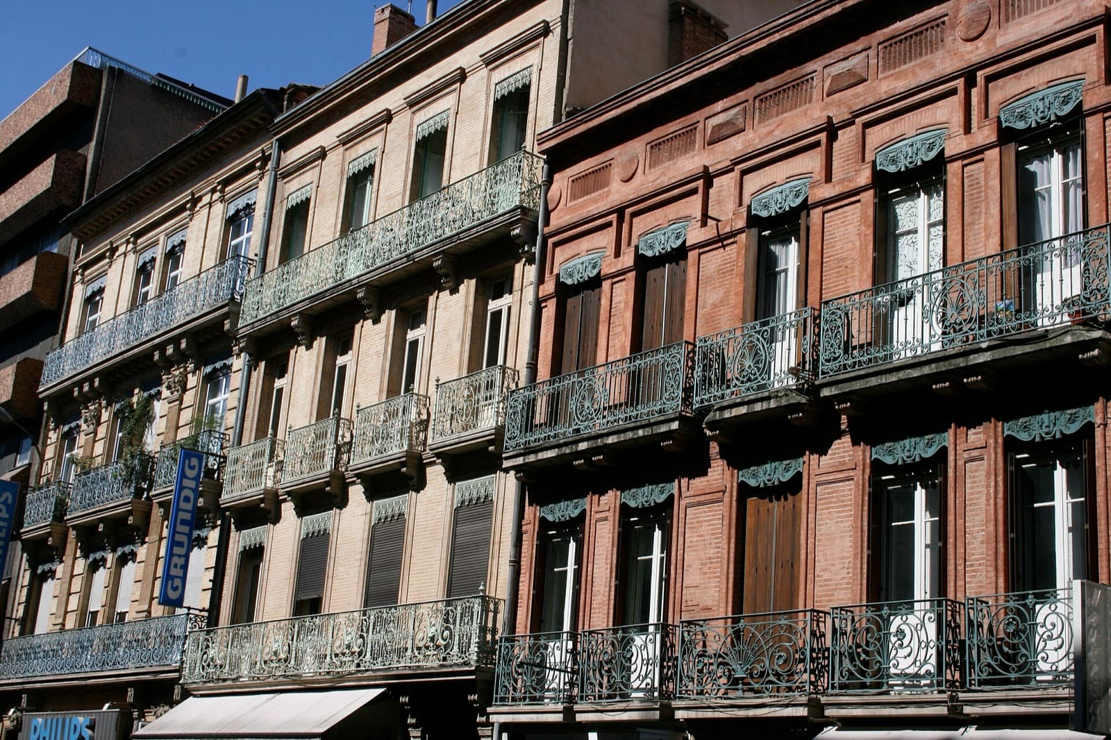 Immeubles anciens de Toulouse en brique rose et orangée, aux balcons de ferronnerie