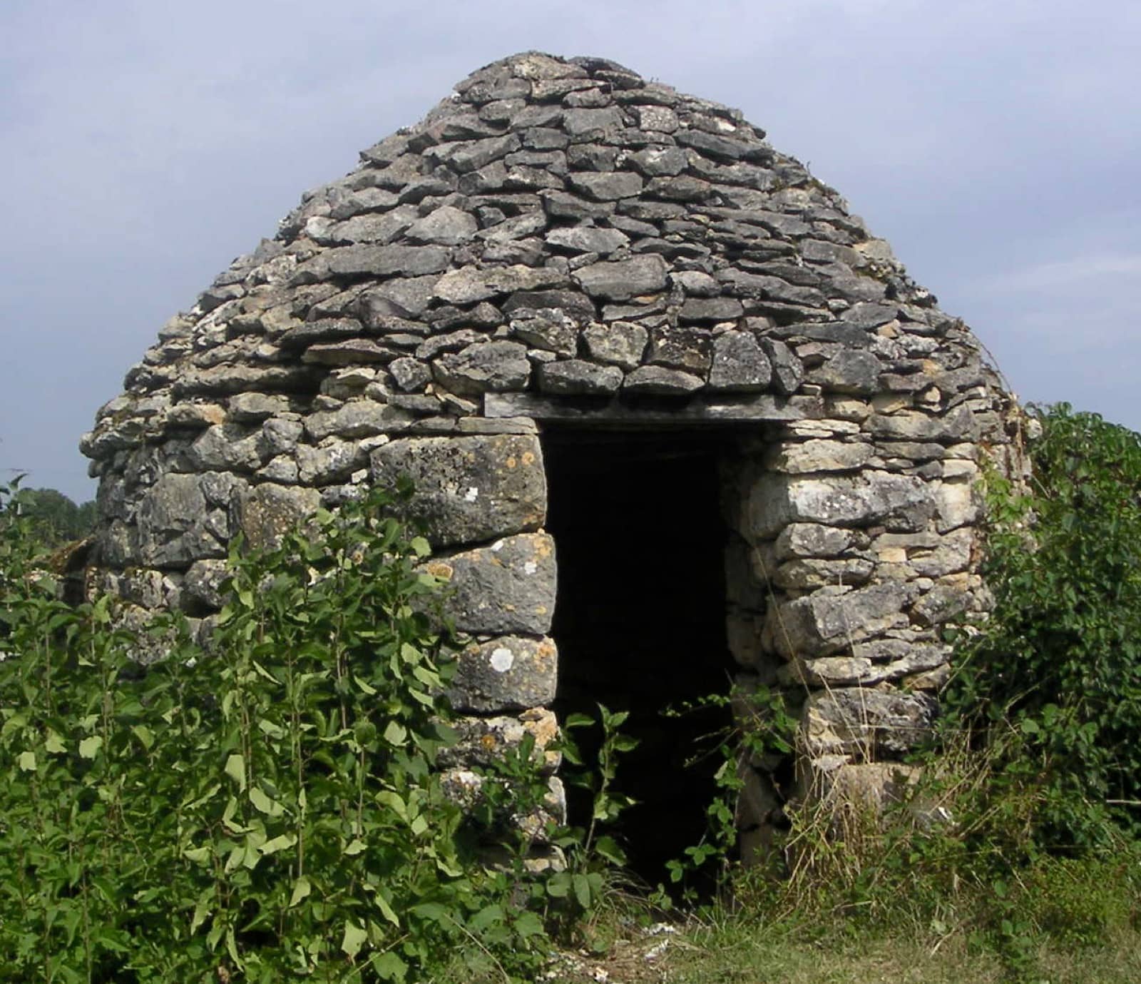 Gariotte de pierre sèche : cabane ronde à toit en encorbellement et porte basse voûtée, sur le causse