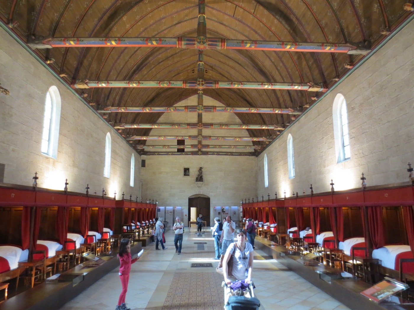 Grande salle des pôvres de l’Hôtel-Dieu de Beaune : plafond de bois lambrissé en berceau, en forme de coque de navire renversée, aux poutres polychromes.