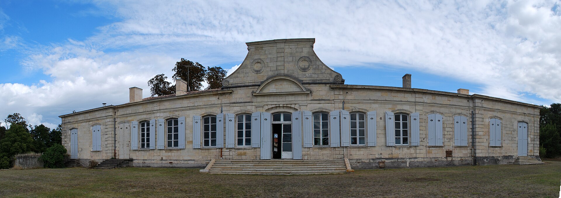 Façade allongée de plain-pied du domaine de Sybirol, aux volets clairs