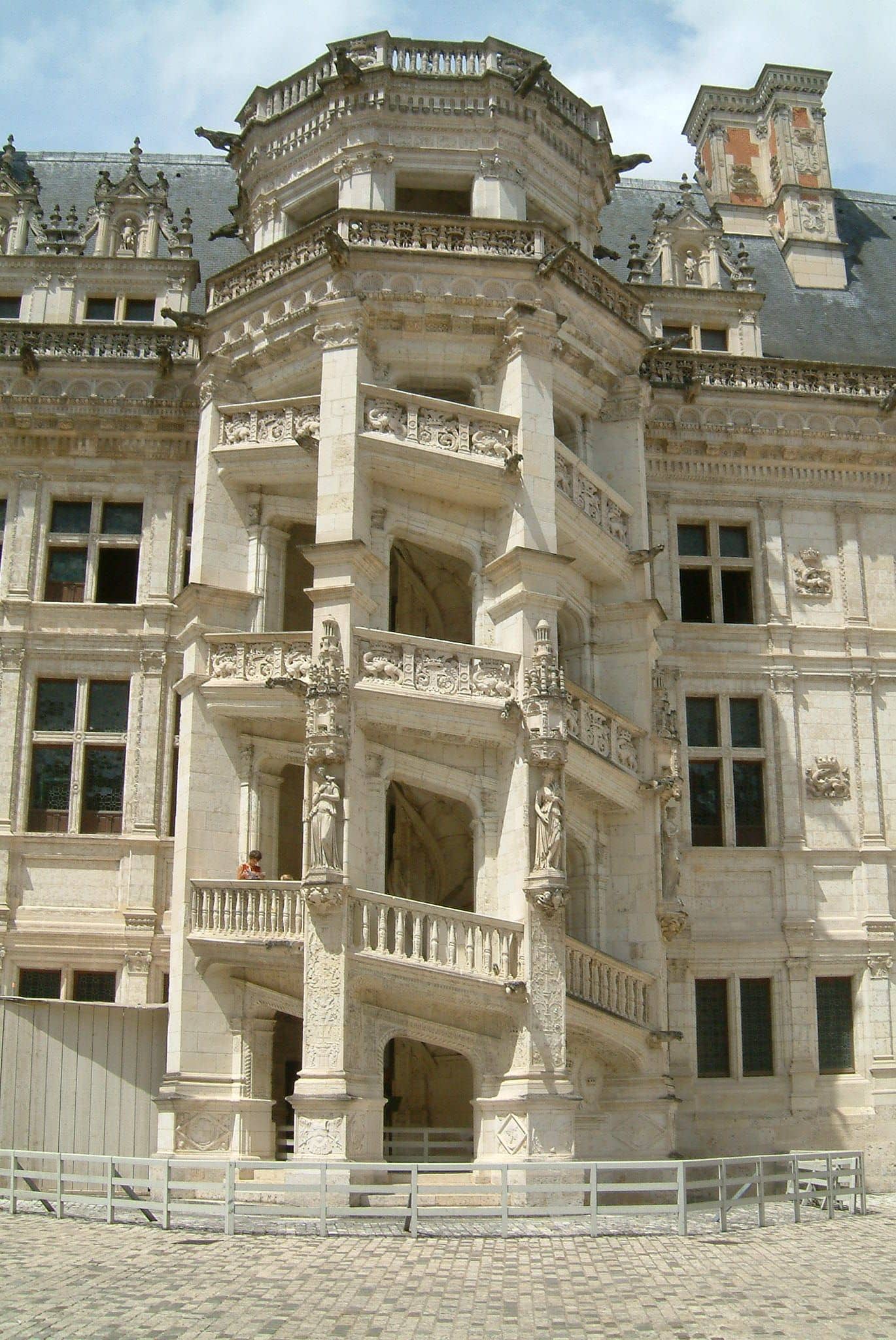 Escalier en vis ajouré de l’aile François Iᵉʳ du château de Blois : tour octogonale à rampes ouvertes, balustrades sculptées, façade voisine ornée de salamandres et de F couronnés
