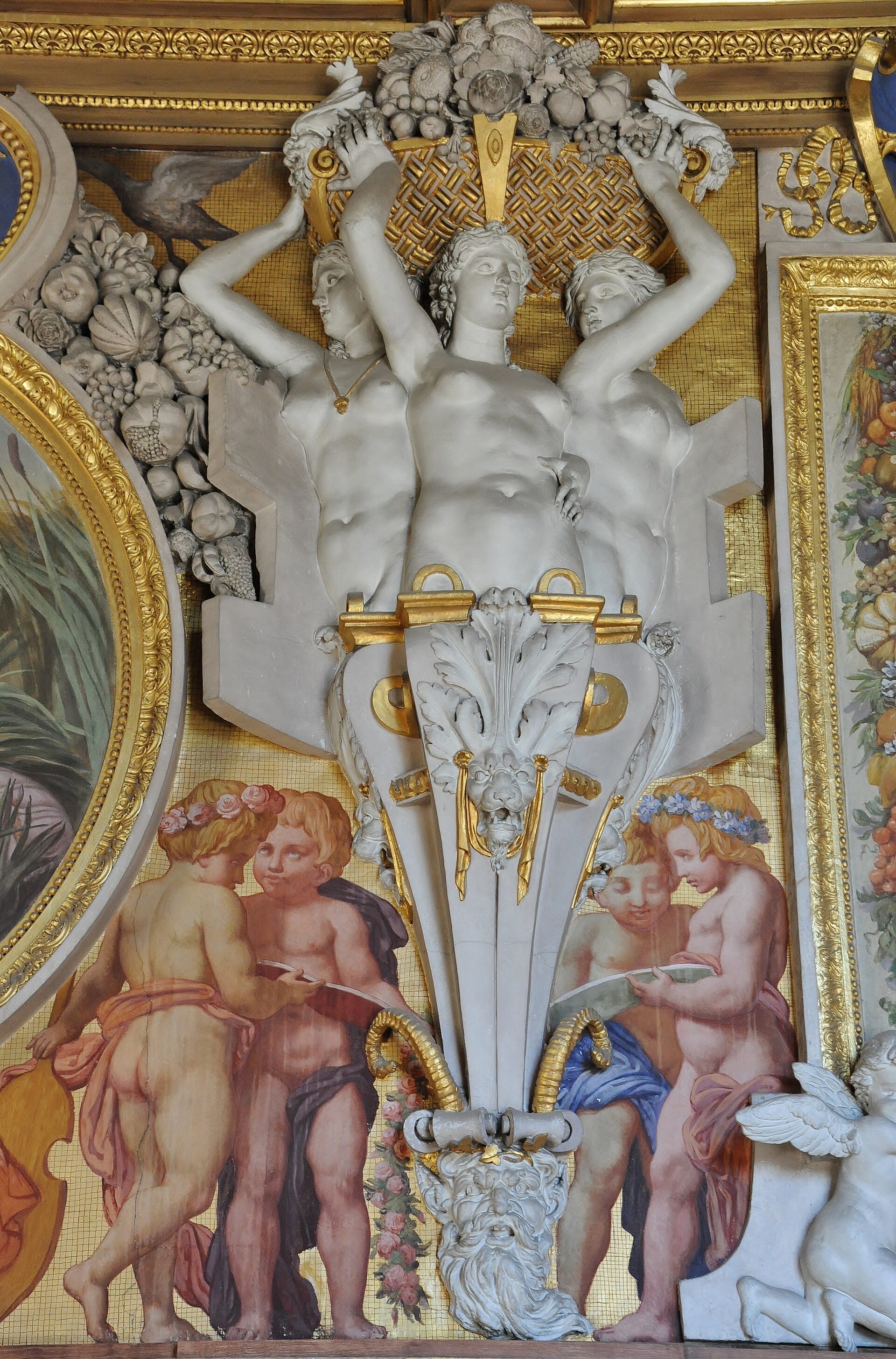 Décor de la galerie François Iᵉʳ à Fontainebleau : figures nues en stuc soutenant une guirlande de fruits, cartouches en cuir découpé doré, putti peints tenant un livre