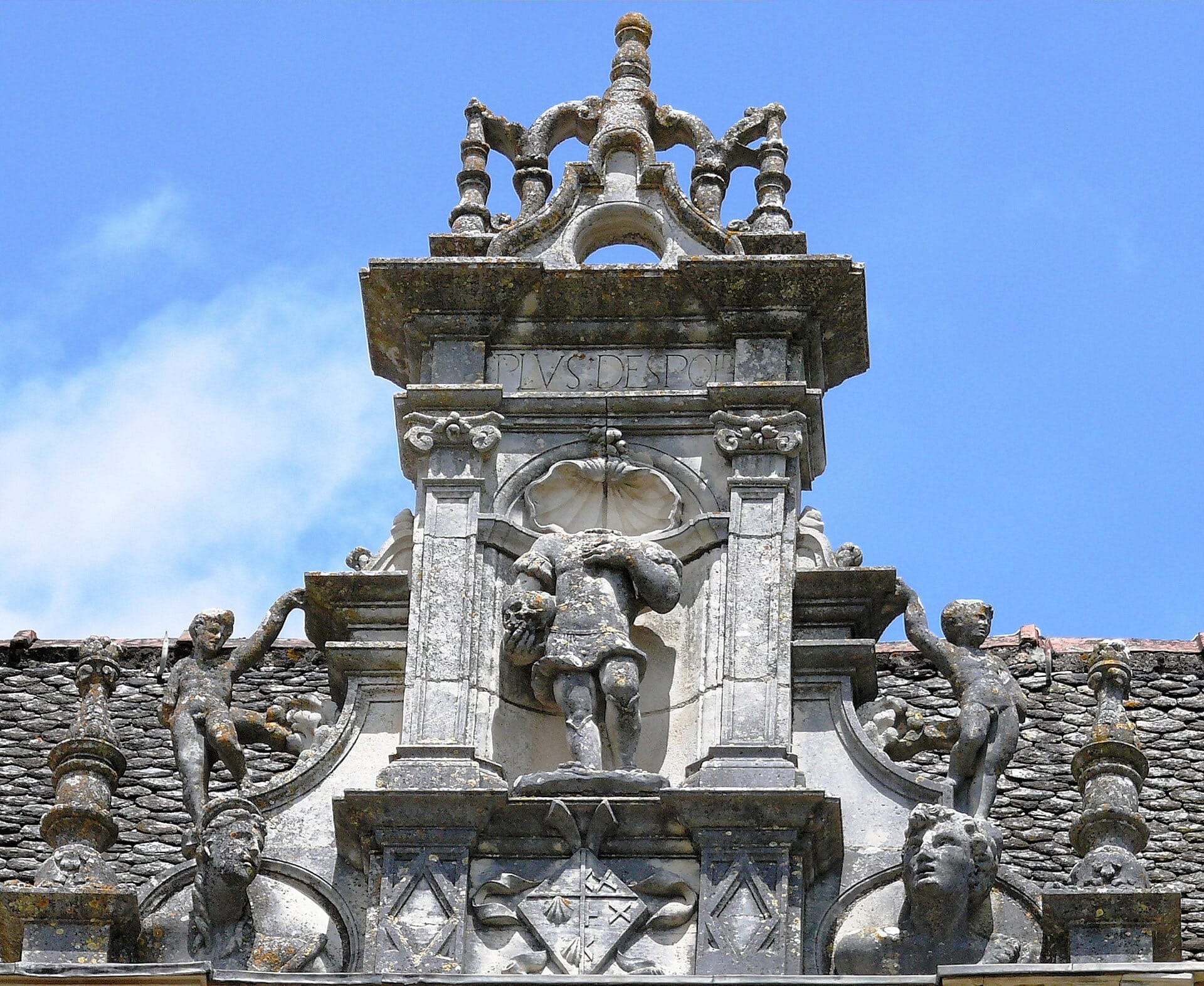 Lucarne sculptée du château de Montal : édicule à pilastres encadrant une niche à statue, coquille, candélabres et cresting ajouré, figures couchées sur le rampant du toit de lauzes