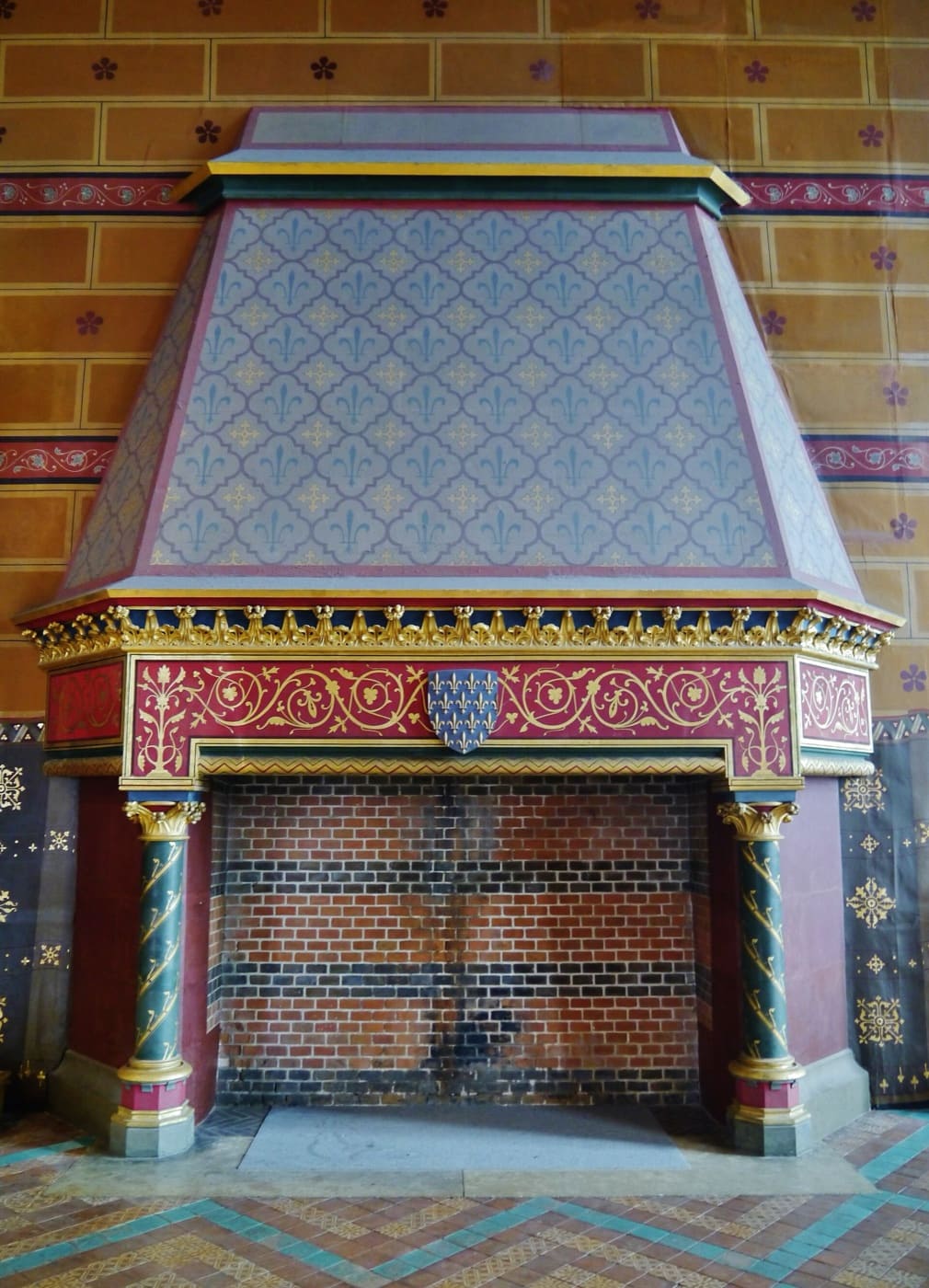 Cheminée monumentale complète de la Salle des États du château de Blois : âtre au sol, jambages et linteau autour de l’ouverture, manteau et hotte sculptés en saillie.