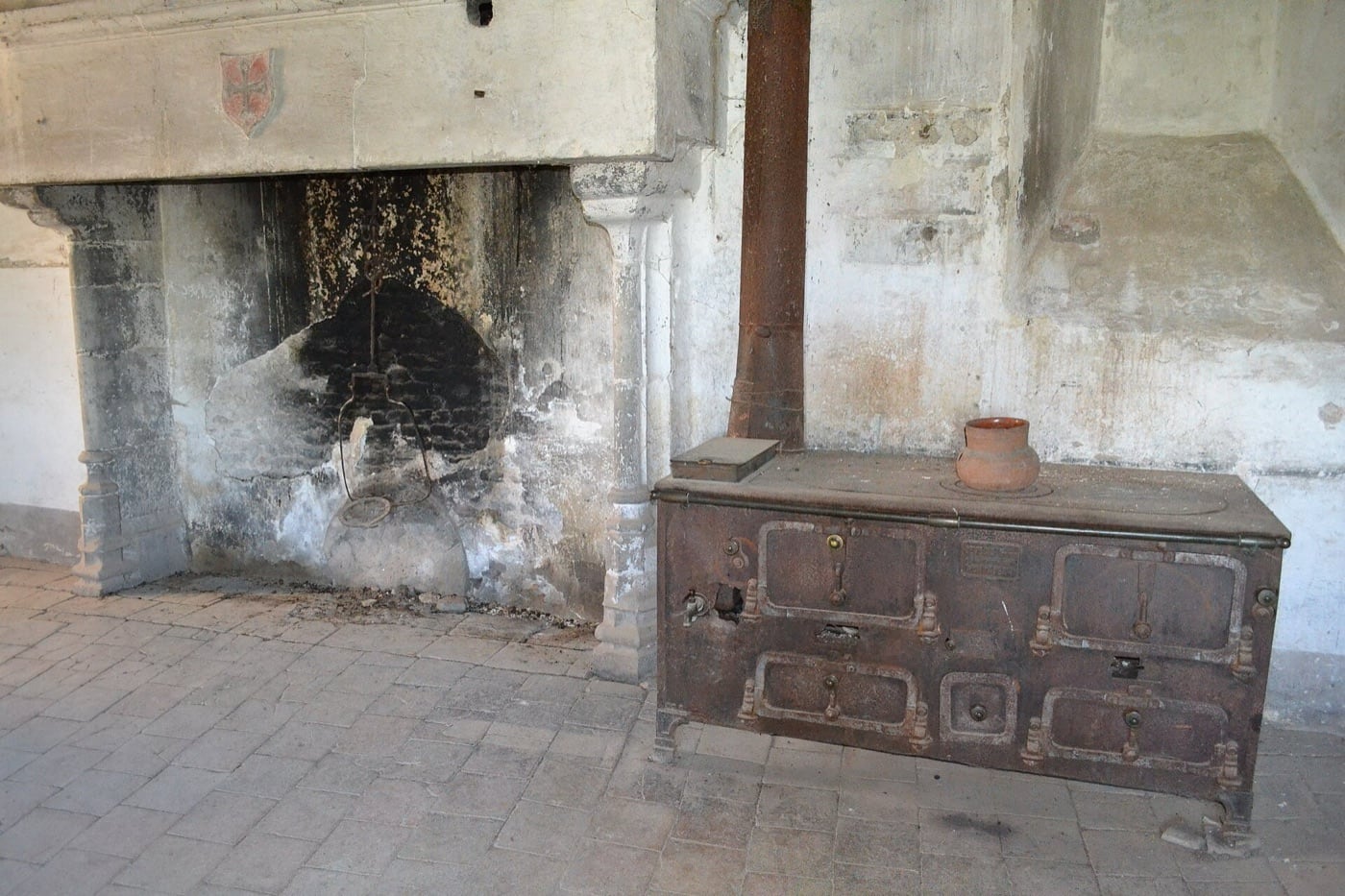 Vaste foyer ouvert en pierre à large ouverture, assez profond pour s’y tenir, dans une salle du château de Bruniquel.