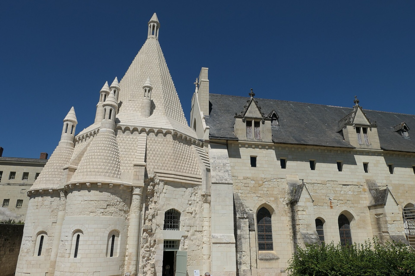 Cuisine romane de l’abbaye de Fontevraud vue de l’extérieur : salle polygonale coiffée d’une couronne de souches de cheminées de pierre.