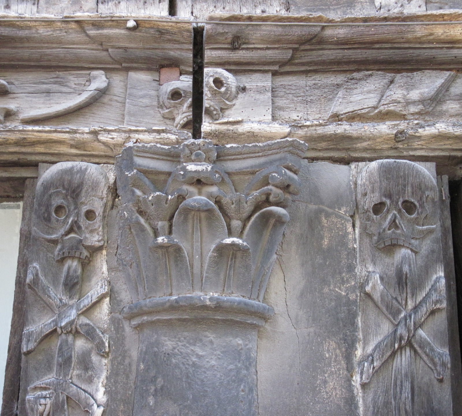 Poteaux de bois sculptés de crânes et d’ossements en croix, galerie de l’Aître Saint-Maclou à Rouen