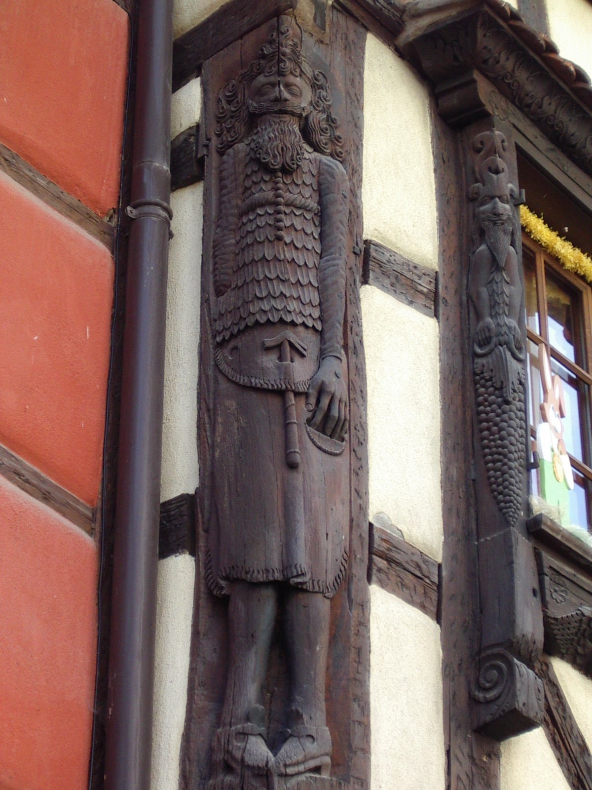 Poteau cornier de bois sculpté d’un personnage barbu, maison à colombages de Riquewihr