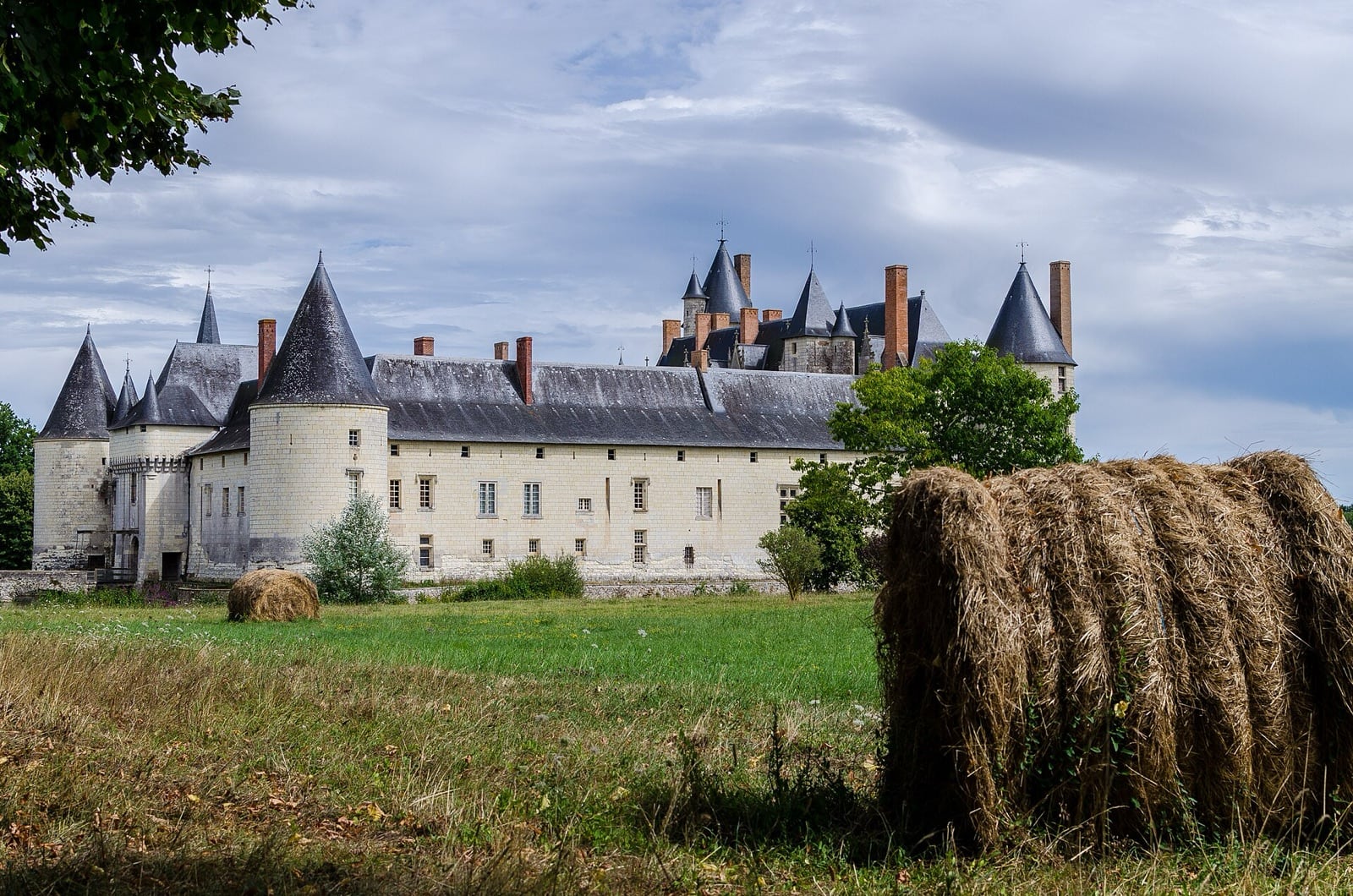 Le château du Plessis-Bourré reflété dans son large plan d’eau, façade à tours d’angle et haut toit d’ardoise