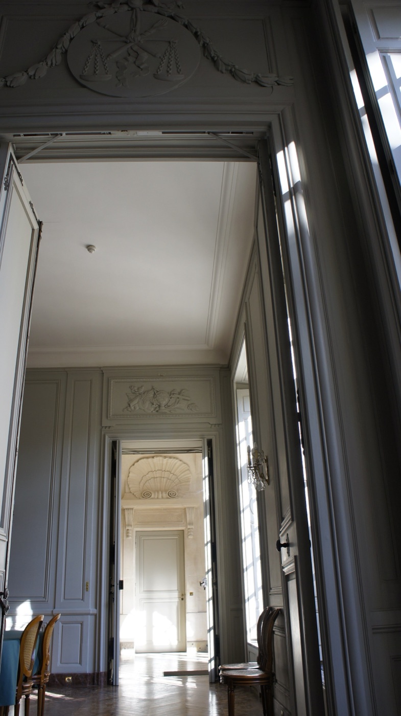 Enfilade conservée dans une demeure ancienne : plusieurs salles reliées par des portes alignées d’origine, prolongeant d’une pièce à l’autre lambris et cheminées.