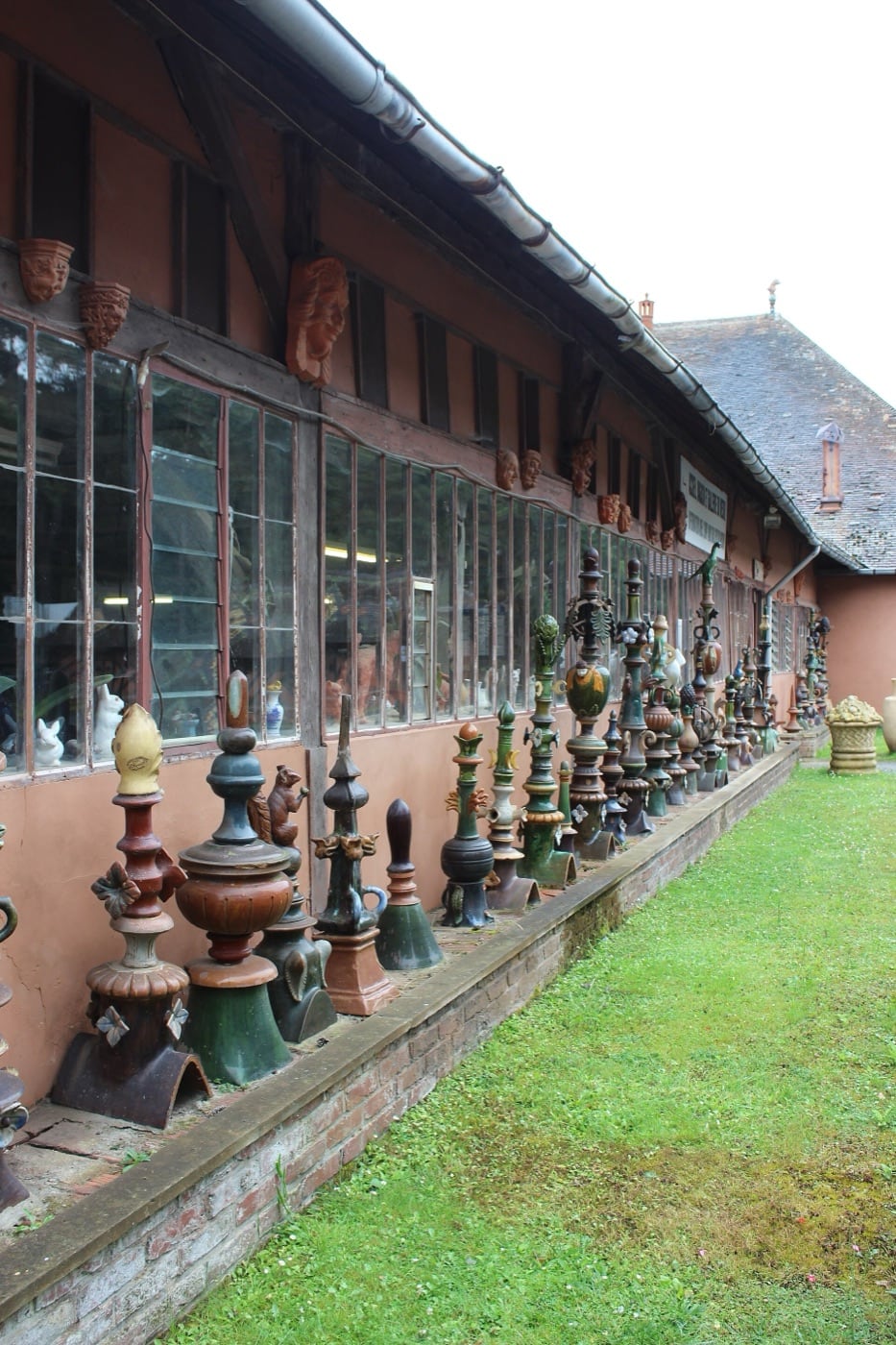 Plusieurs épis de faîtage en terre vernissée aux formes et couleurs variées, produits par la poterie du Mesnil de Bavent.