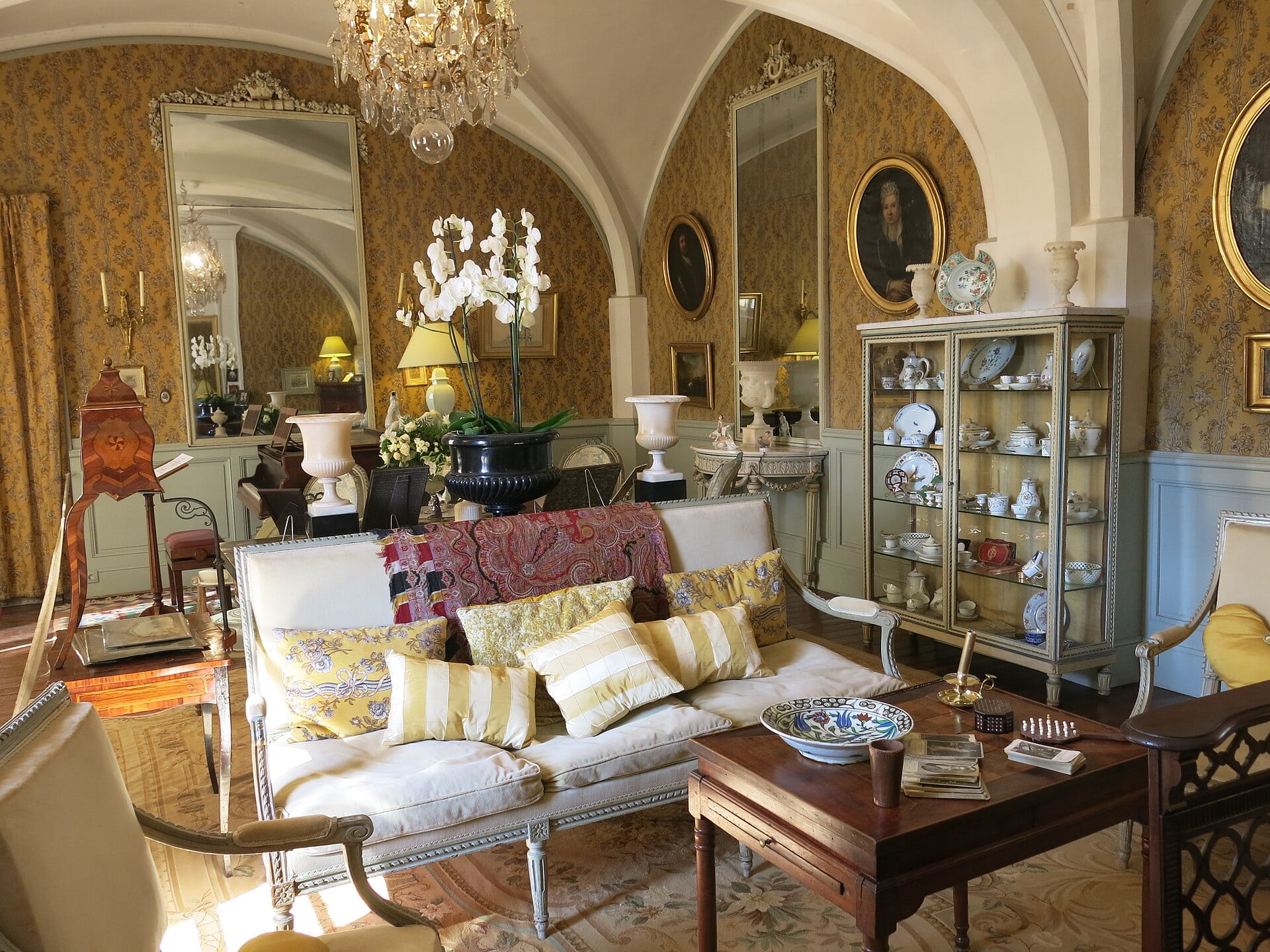 Salon richement meublé du château de Flaugergues, canapé et vaisselier