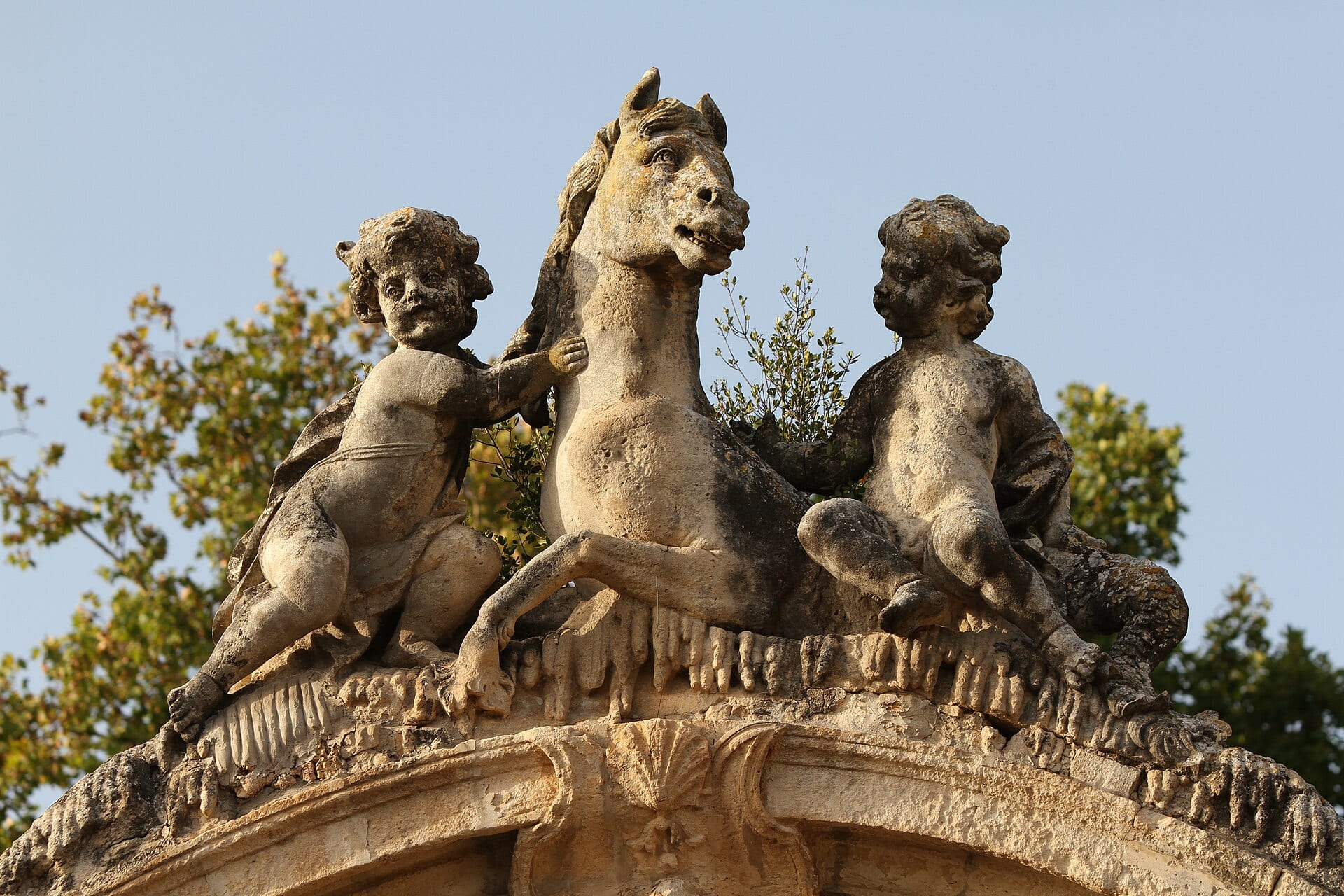 Groupe sculpté de chevaux et putti ornant le parc du château de la Mogère