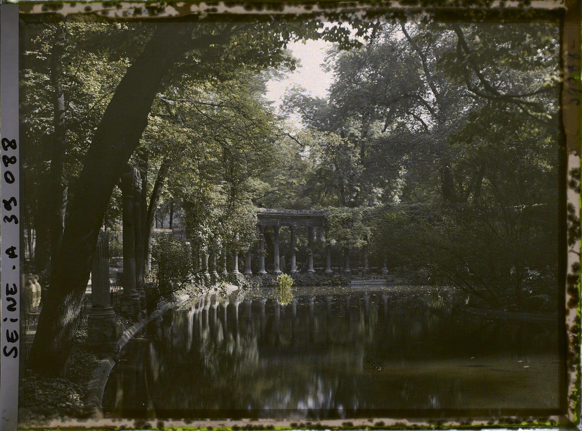 Colonnade de la naumachie du parc Monceau reflétée dans le bassin, photographie ancienne colorisée