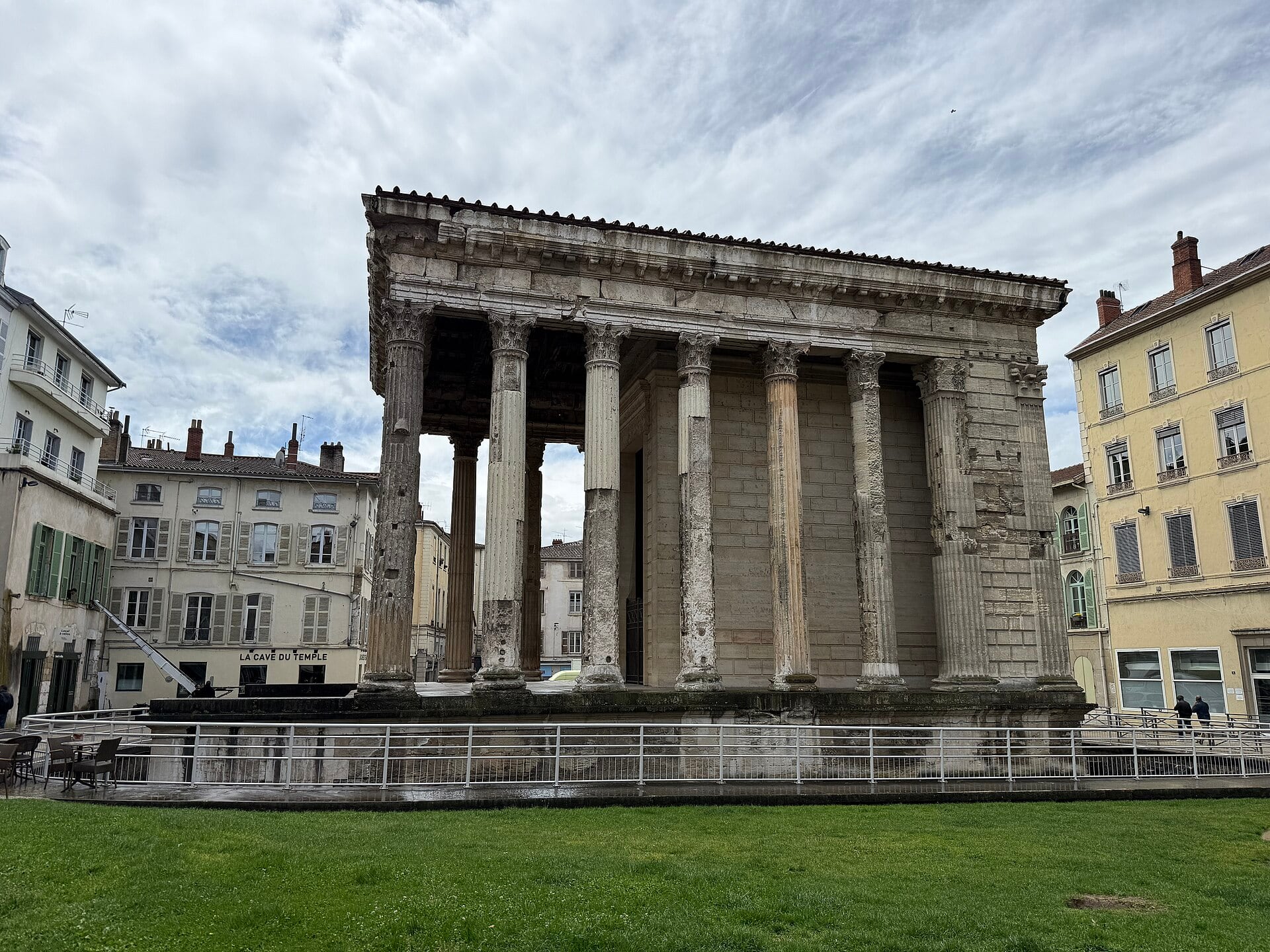Le temple d’Auguste et de Livie à Vienne : temple romain corinthien dressé sur un podium, colonnes cannelées et fronton, conservé entre les immeubles de la ville