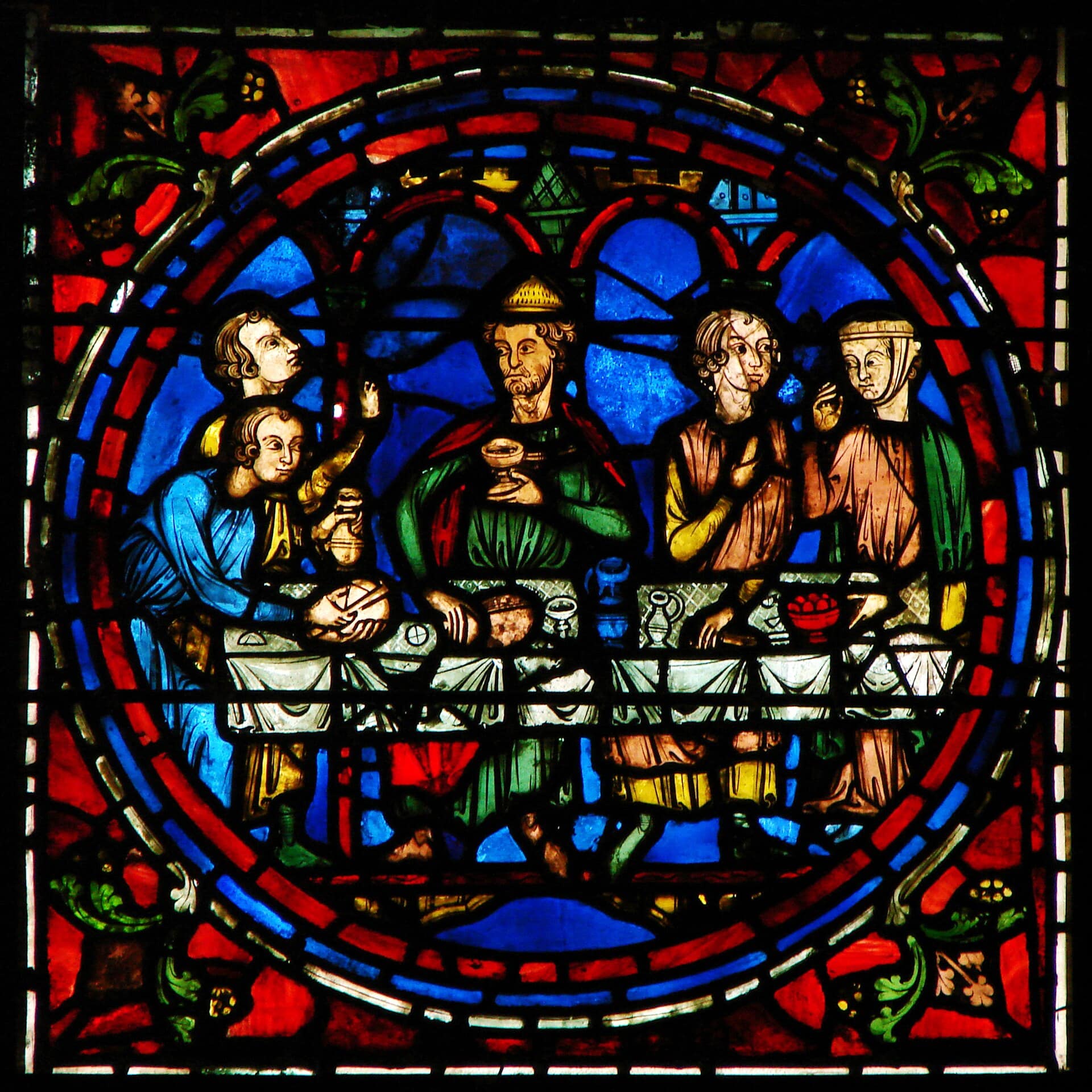 Médaillon de vitrail gothique de la cathédrale de Chartres : scène figurée de plusieurs personnages attablés, verre rouge et bleu cerné de plomb