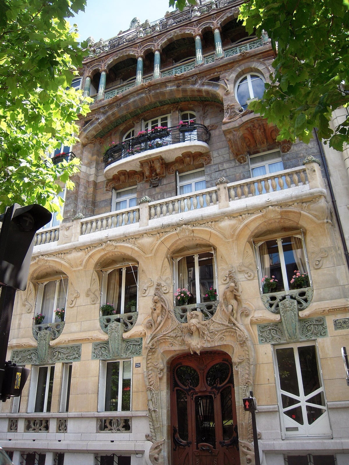 Façade de l’immeuble Lavirotte, 29 avenue Rapp à Paris : décor Art nouveau exubérant en pierre sculptée et grès flammé, figures féminines, balcons en fer forgé et porte ouvragée
