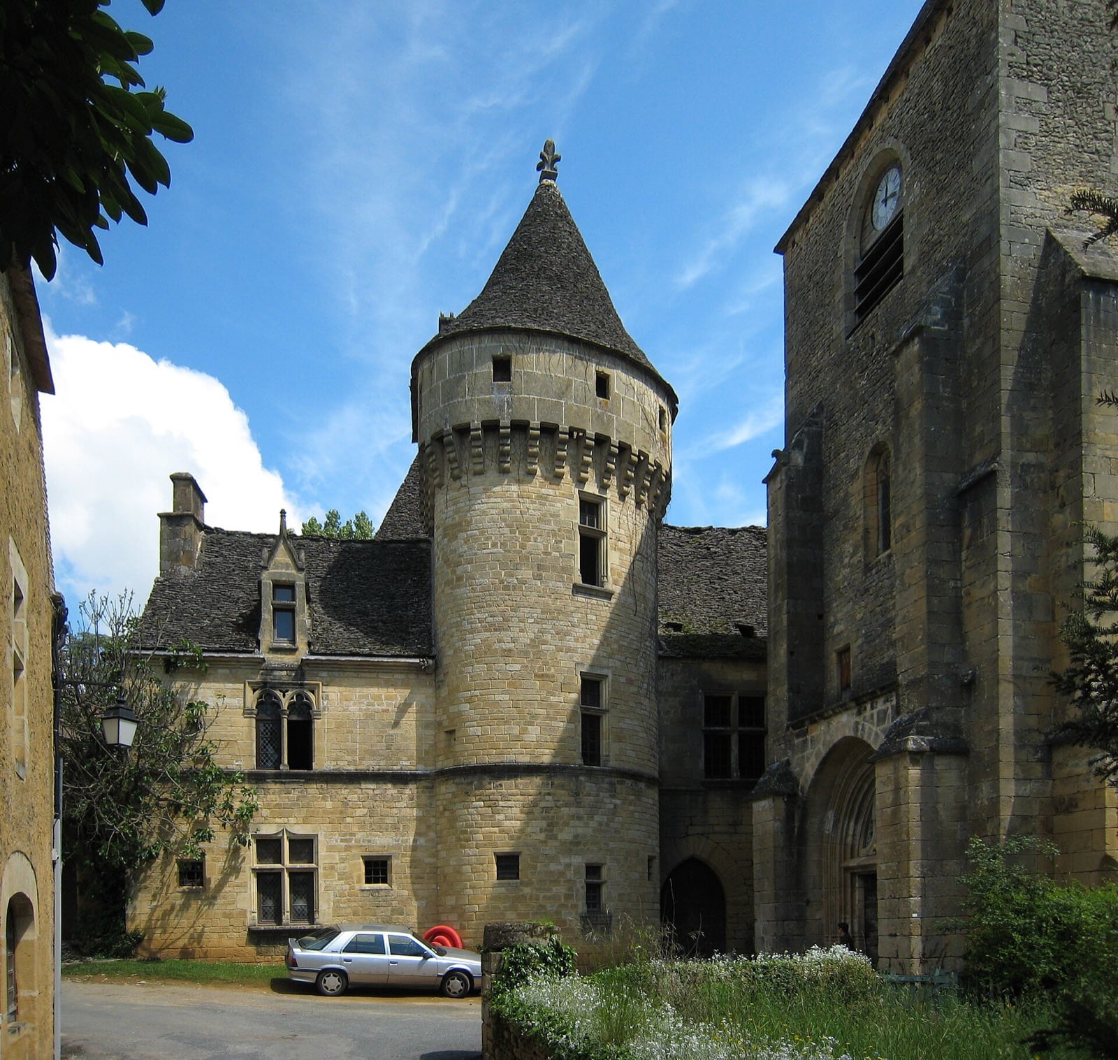 Manoir et clocher de Saint-Geniès en Périgord noir, murs de pierre blonde et toits de lauze