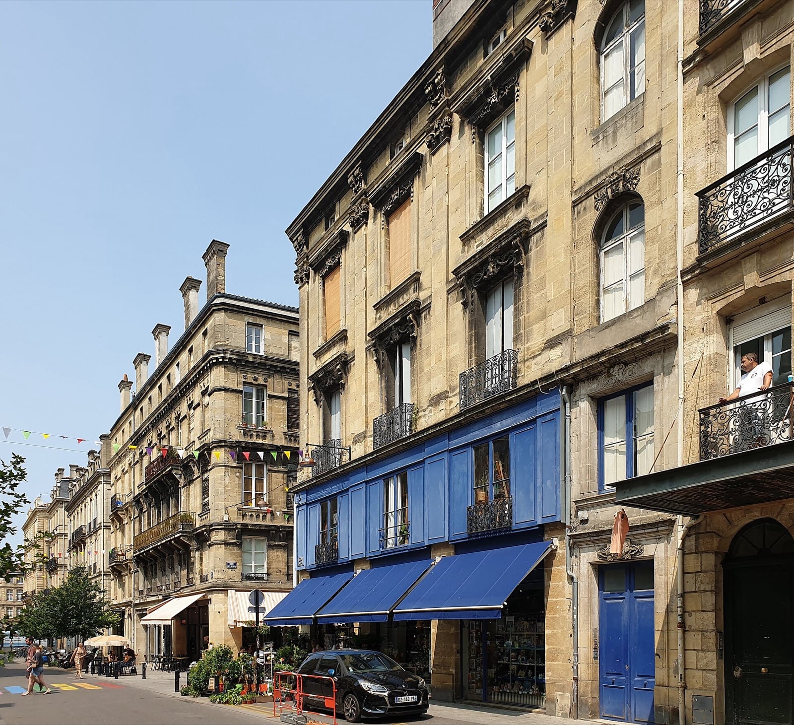 Rue de Bordeaux bordée de façades en pierre de taille claire à travées régulières, clés sculptées et balcons de fer forgé.