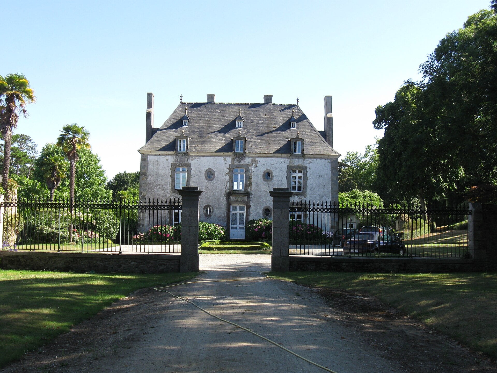 Château de la Ravillais à Ploubalay, façade classique à toit à la Mansart derrière une grille