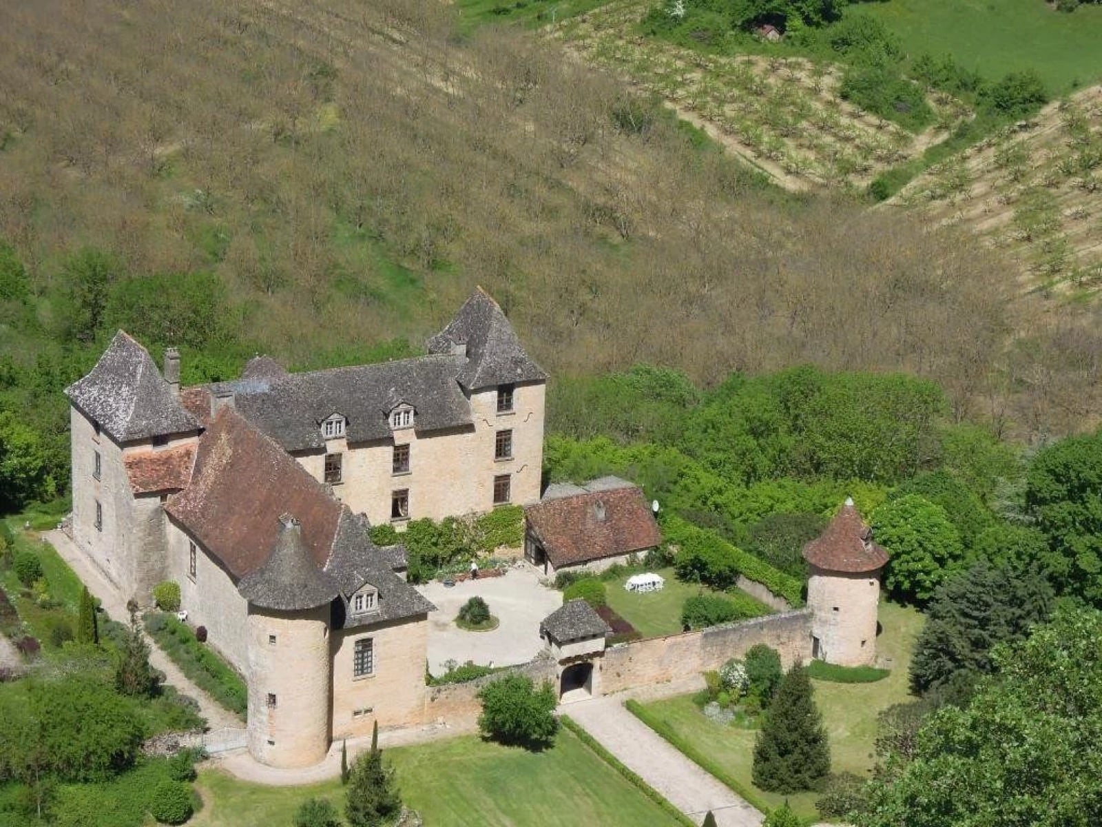 Château quercynois en pierre calcaire ocre à tourelles, dans le Lot