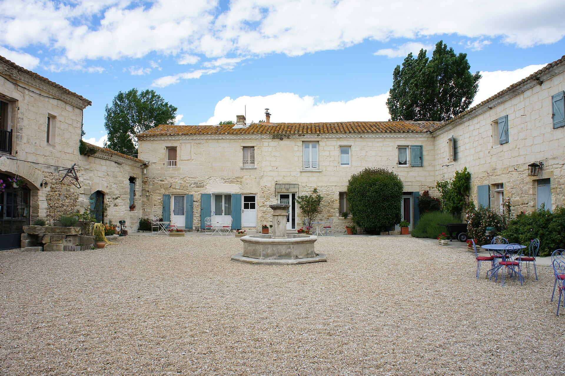 Cour du mas de Sylvéréal en Camargue, corps de bâtiments disposés en U autour d’une fontaine
