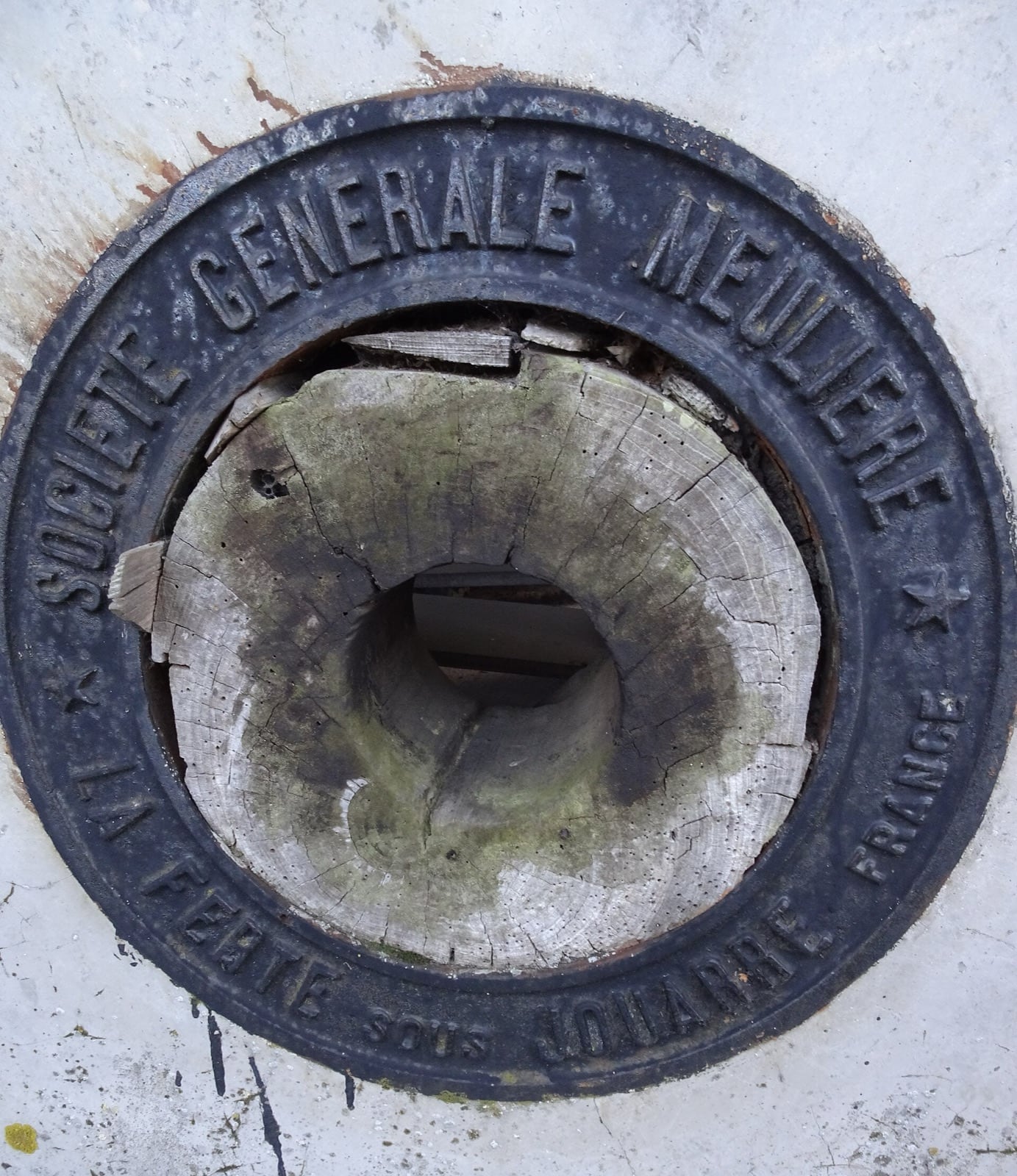 Meule de moulin cerclée de fonte portant l’inscription « Société Générale Meulière — La Ferté-sous-Jouarre »