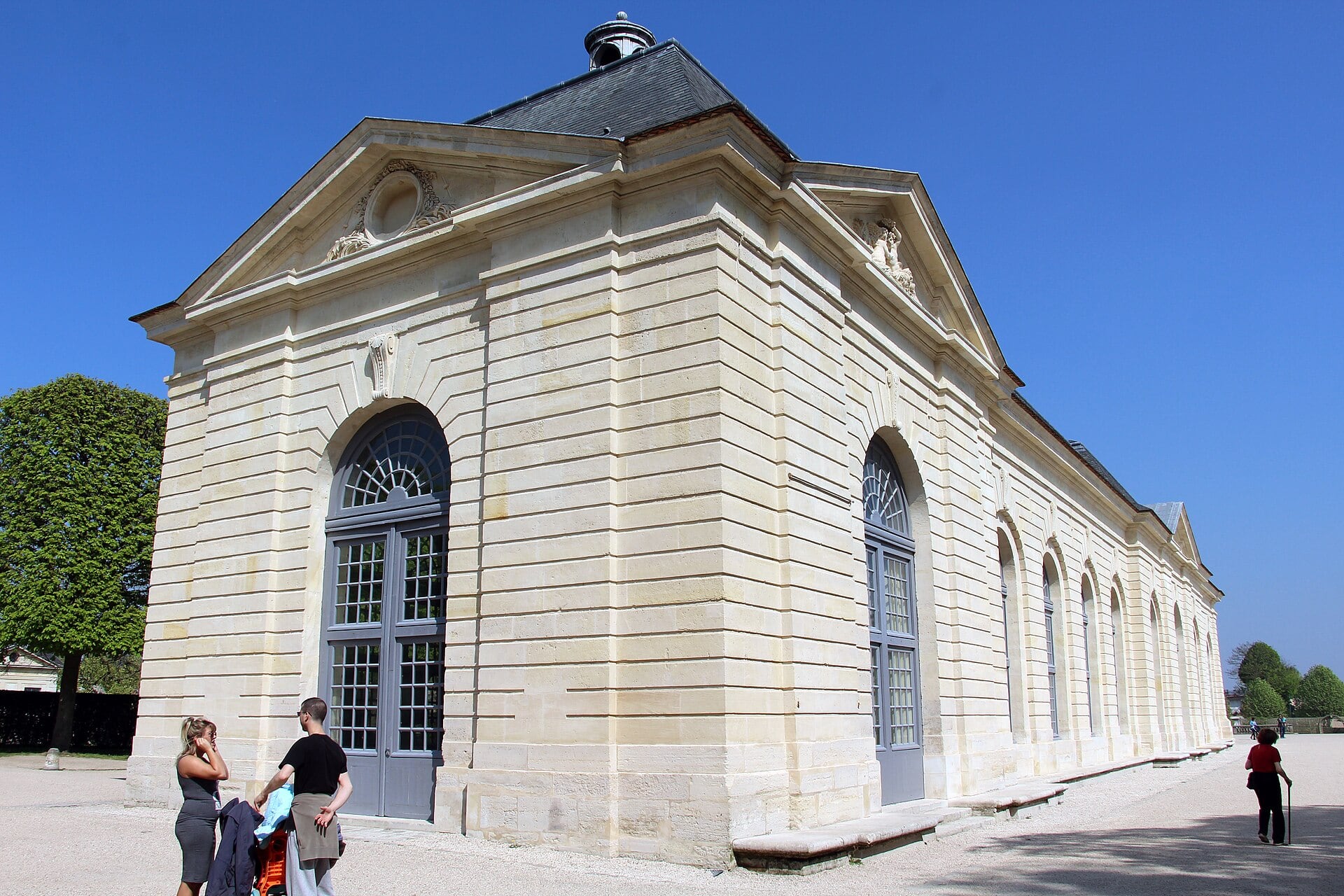 L’orangerie du château de Sceaux : pavillon classique de pierre à fronton et hautes baies cintrées, lanternon au faîte.