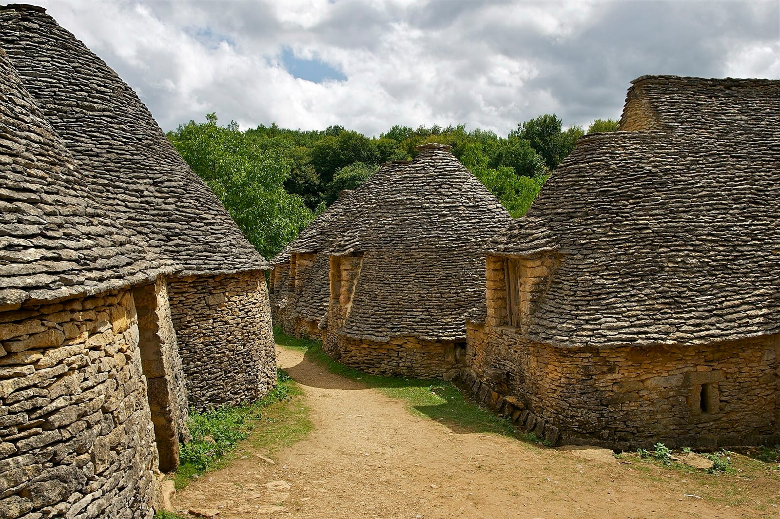 Groupe de cabanes de pierre sèche aux toits coniques de lauzes calcaires, aux Cabanes du Breuil en Périgord