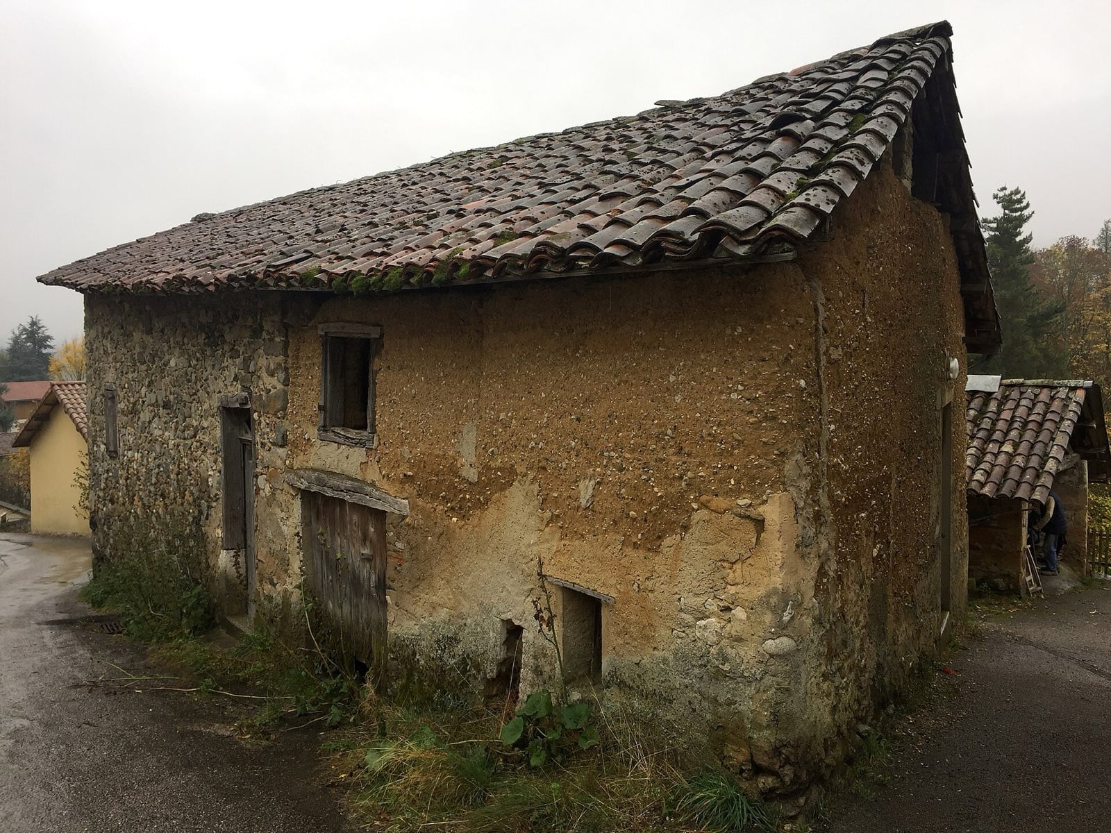 Vieille maison de pisé à Saint-Nicolas-de-Macherin, murs de terre mêlée de galets et toit de tuiles patinées