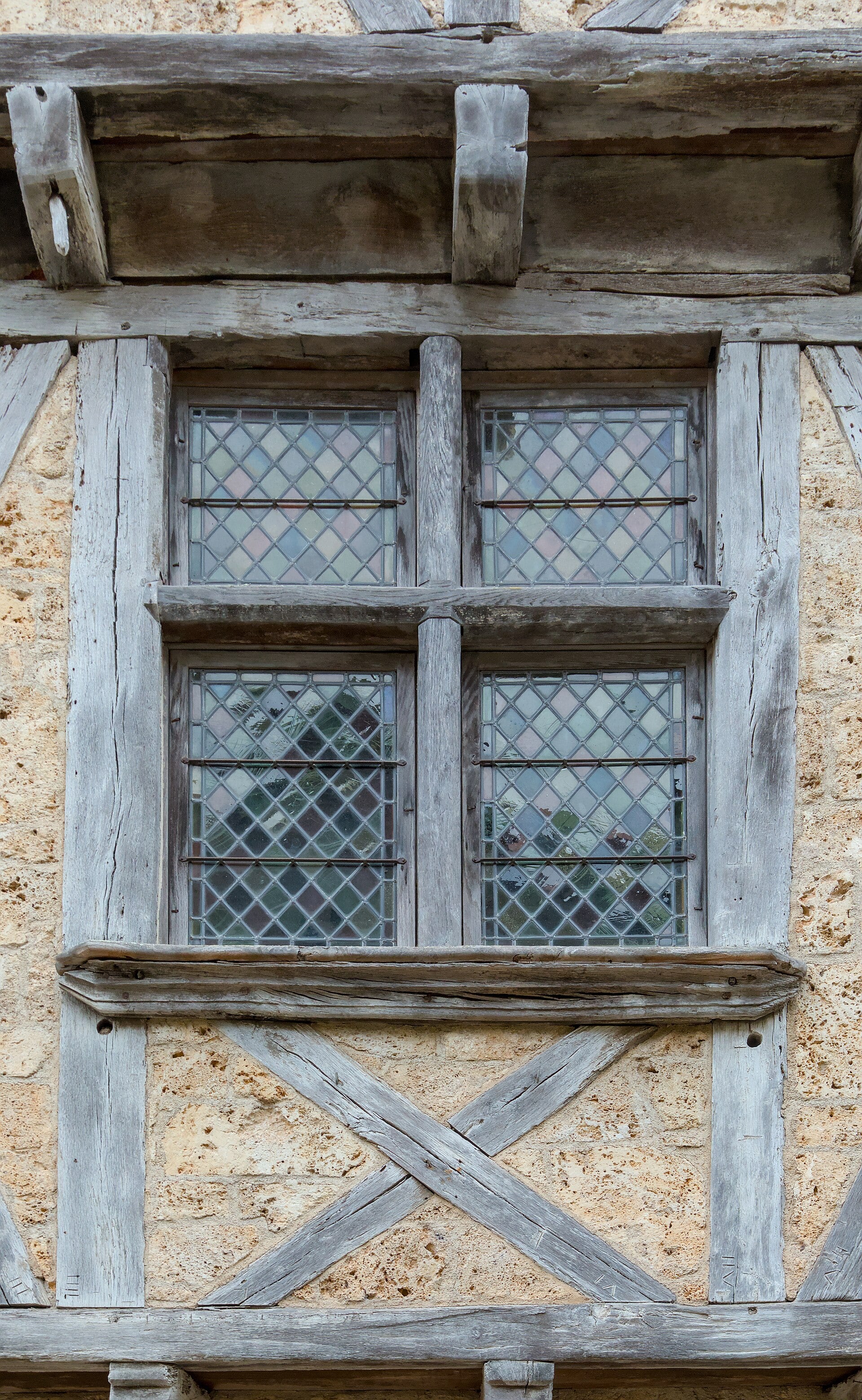 Fenêtre à croisée de pierre entourée de pans de bois, façade gothique à Saint-Cirq-Lapopie