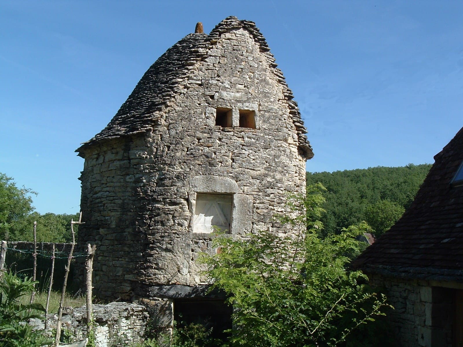 Haute maison de pierre à étage surmontée d’un pigeonnier, à Espagnac-Sainte-Eulalie