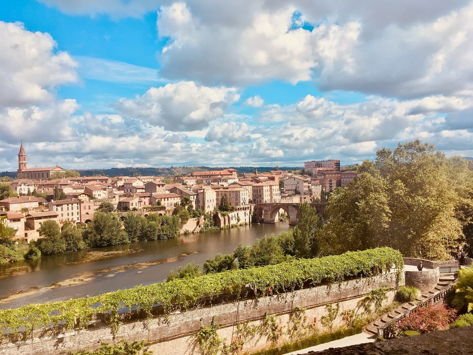 Albi vue depuis les jardins du palais de la Berbie : maisons de brique et de tuile étagées au-dessus du Tarn, arches du Pont-Vieux