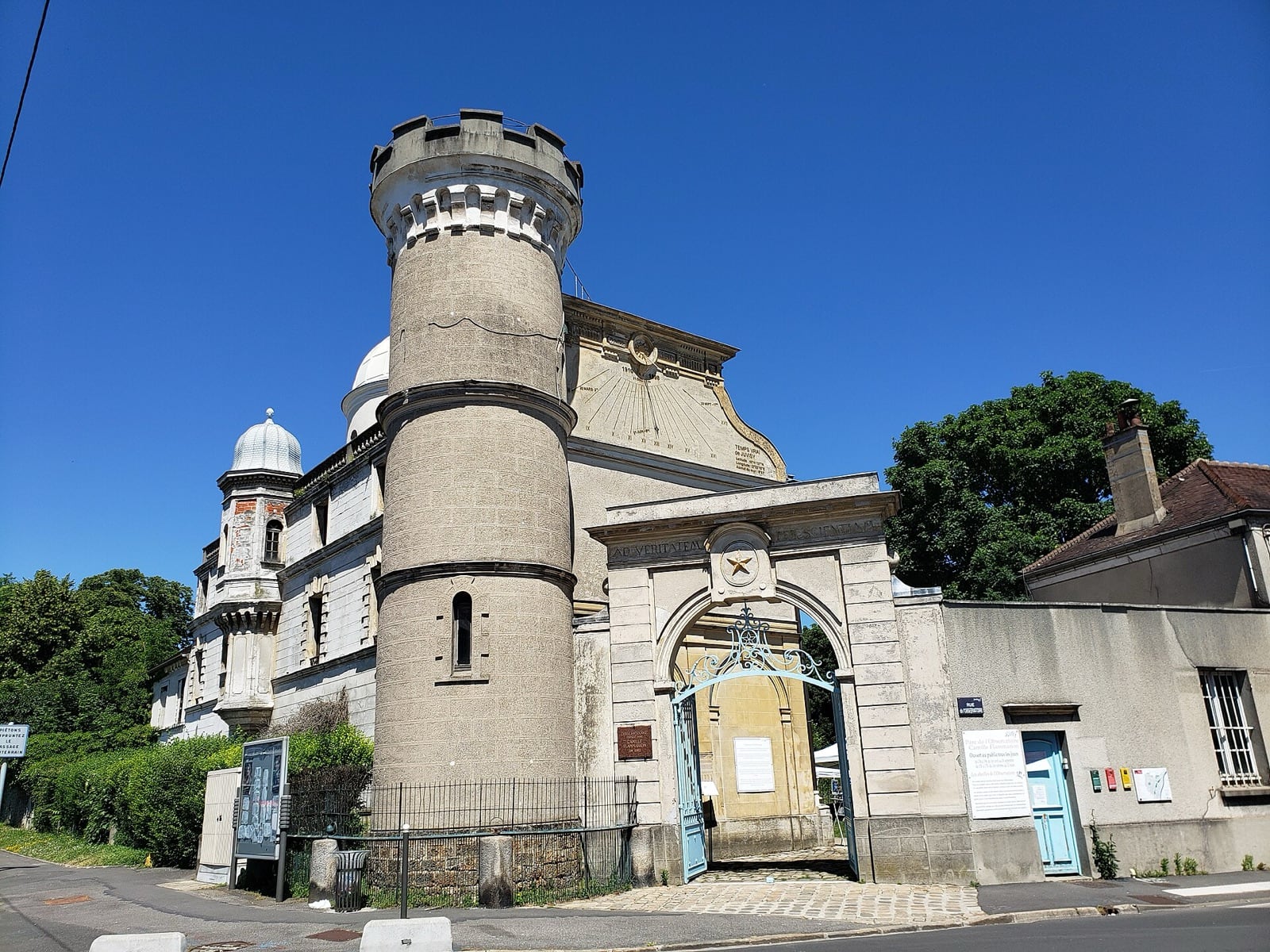 Bâtiment de pierre à tour cylindrique crénelée et coupole d’observatoire, précédé d’un portail monumental en arc ; site de l’observatoire Camille-Flammarion à Juvisy-sur-Orge.