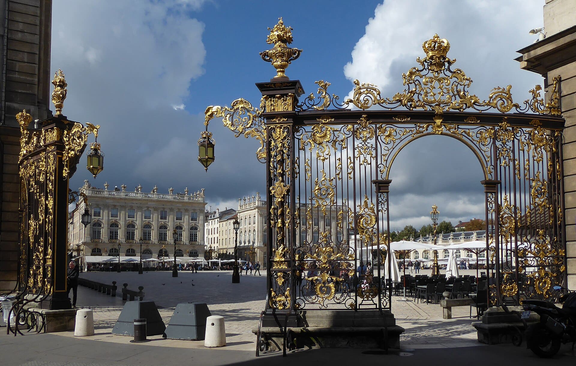 Les grilles dorées de Jean Lamour à la place Stanislas de Nancy : ferronneries rocaille à volutes, coquilles et couronne dorées, ouvrant sur la place et ses pavillons classiques