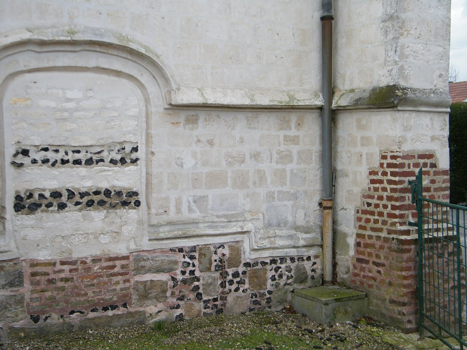 Appareil de silex taillé et de pierre blanche disposé en damier sur un mur d’église picarde, à Vironchaux
