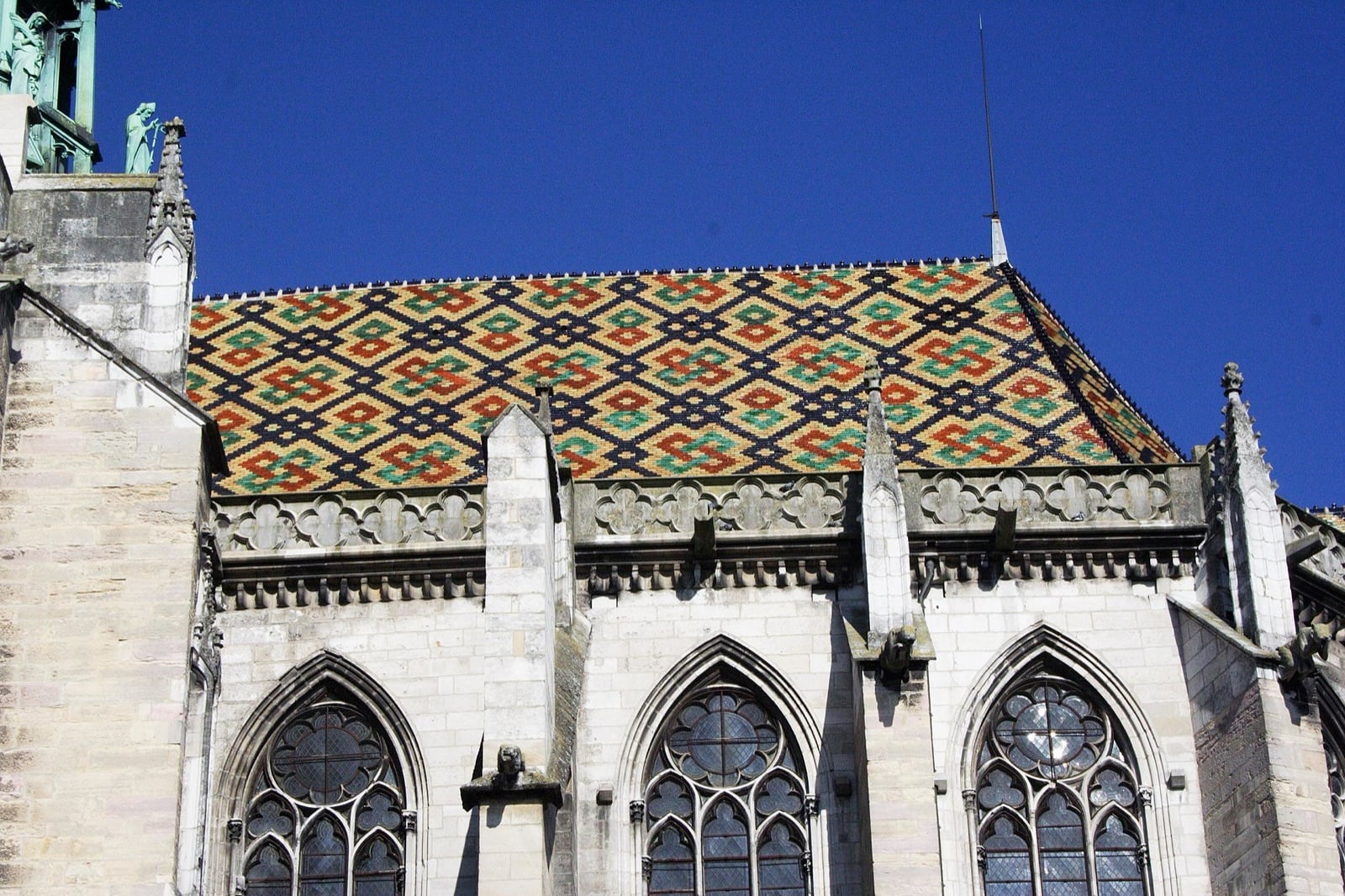 Toiture de tuiles plates vernissées de la cathédrale Saint-Bénigne de Dijon, dense semis de losanges rouges, verts et or sur fond noir