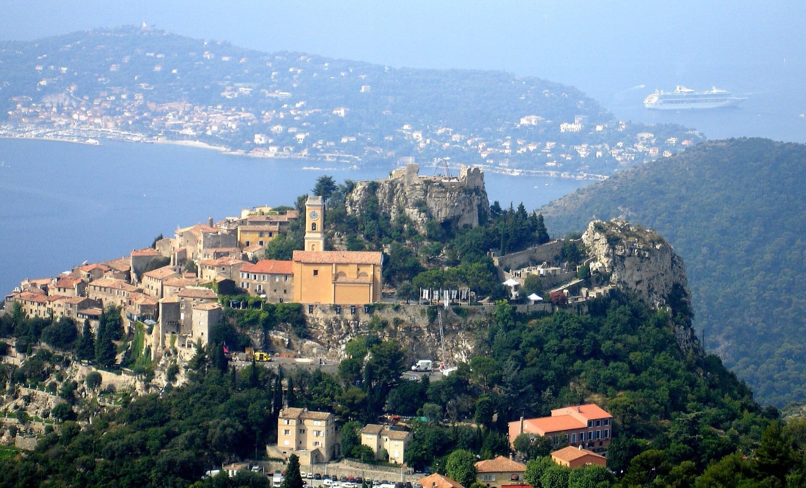 Èze vu de la Grande Corniche : le village et les ruines du château au sommet d’un piton, la Méditerranée en contrebas
