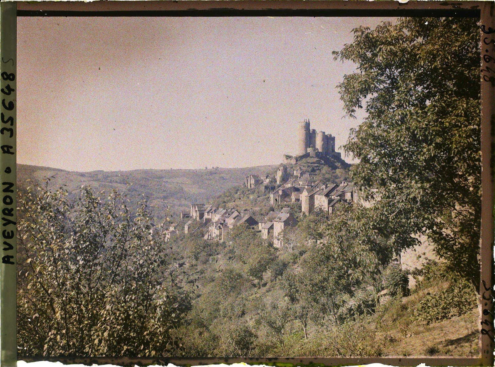 Autochrome ancienne de Najac : le village aligné en crête sur son éperon, la forteresse à tours rondes à l’extrémité