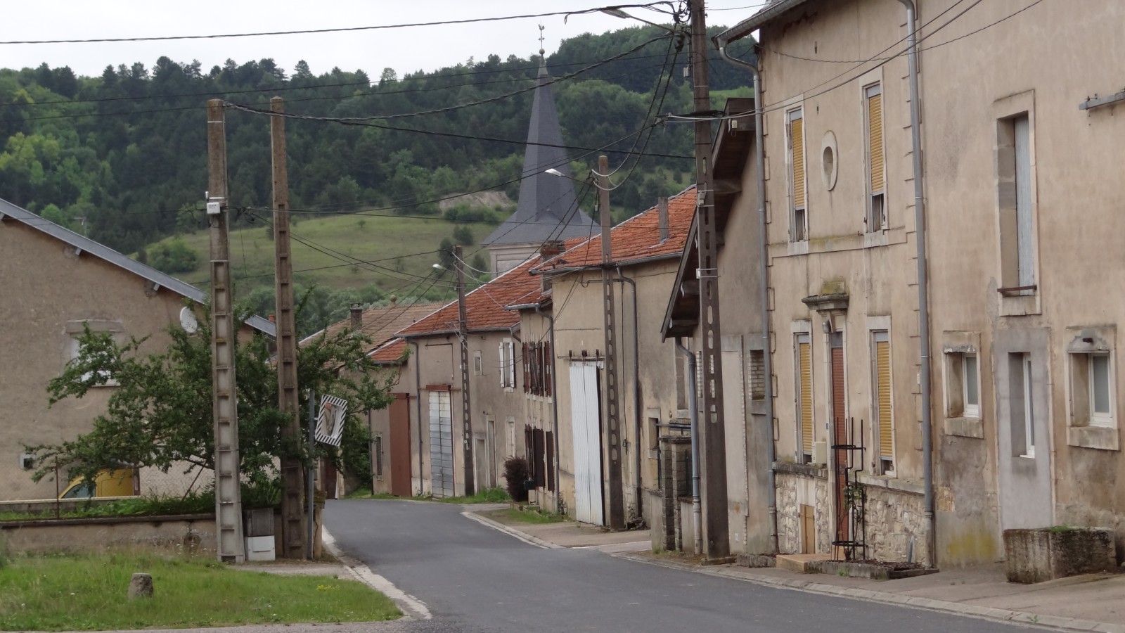 Rue du Milieu à Han-sur-Meuse : file continue de façades de fermes lorraines et de portes charretières