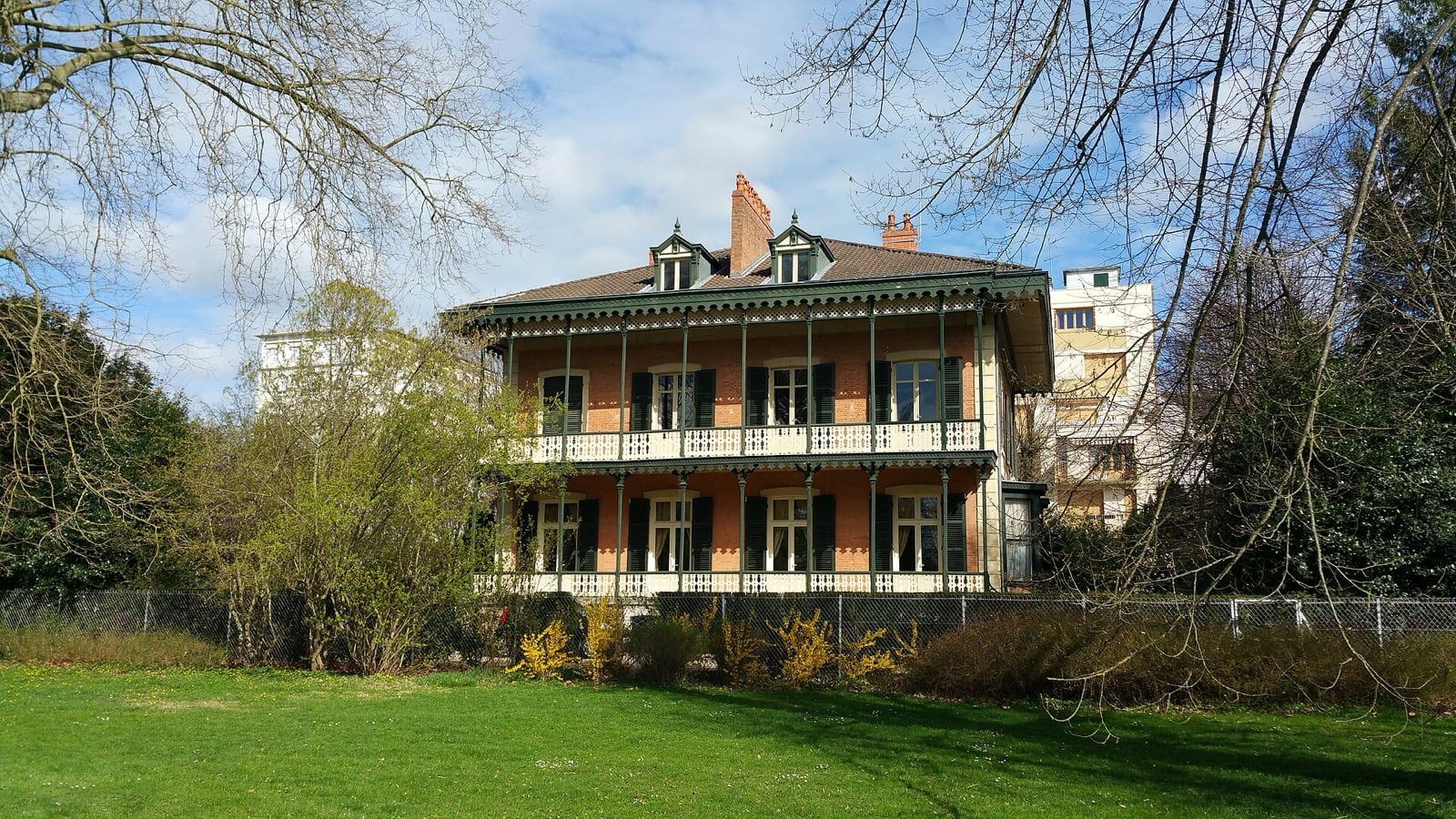 Un chalet Napoléon III du parc de Vichy : façade à pans de bois, balcons de fonte peints sur deux niveaux